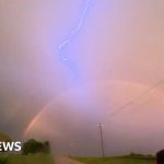 Driver captures lightning over a rainbow in Iowa